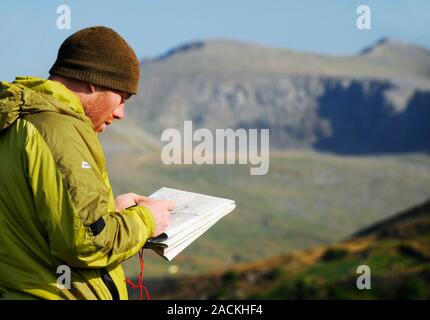 Mountain navigation, using a compass and map. Photographed in Snowdon National Park, Wales. Stock Photo