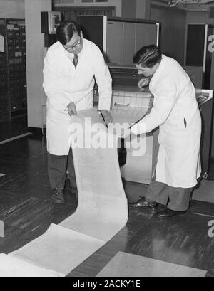 Met Office KDF9 computer. Computer operatives examining the forecasts printed by the high-speed printer of the KDF9, an early computer produced by the Stock Photo