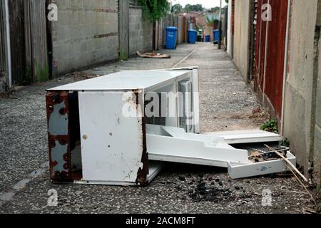 Flytipping. Old fridge dumped in an alley. Stock Photo