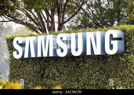 Nov 27, 2019 San Jose / CA / USA - Samsung Sign displayed in front of the modern headquarters of Samsung Electronics Device Solutions America in Silic Stock Photo