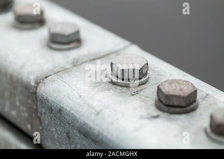 Abstract industrial background with gray bolts in a row, close-up photo with selective soft focus Stock Photo