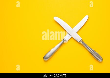 Two knife on yellow background with copy space. Top view. Flat lay. Pattern. Zero waste, save the planet, danger of plastic. Stock Photo