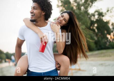 Smiling couple having fun over sky background. Holidays, vacation, love and friendship concept
