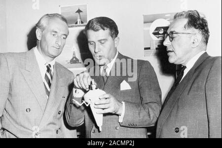 Von Braun discussing spacesuit. At centre, German-US rocket scientist Wernher von Braun (1912-1977), is holding a 'bottle suit' model of a TV show spa Stock Photo