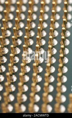 Microprocessor gold-plated contact pins. Close-up of the underside of a computer's central processing unit (CPU), showing the numerous contact pins (g Stock Photo