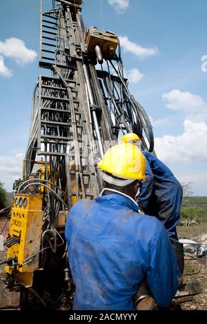 Mineral exploration drilling. Drillers changing the diamond drill bit on a multi-combination drilling rig during a mineral exploration project. This r Stock Photo
