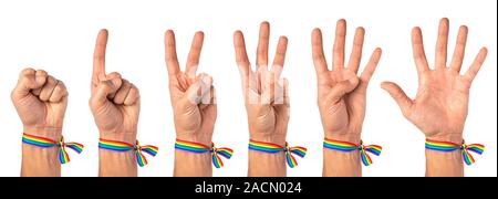 Man shows the numbers on his fingers, one, two, three, four, five. Pride male hand with rainbow LGBT tape. Isolated on a white background. Stock Photo