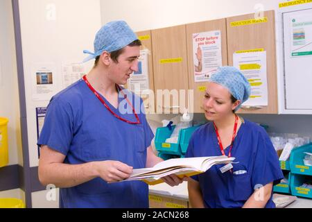 Surgeons discussing patient notes on a hospital ward Stock Photo