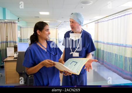 Surgeons discussing patient notes on a hospital ward Stock Photo