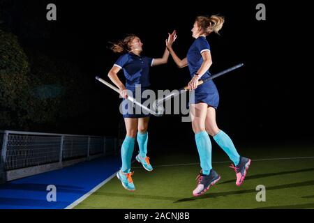 Two female field hockey players celebrate the victory Stock Photo