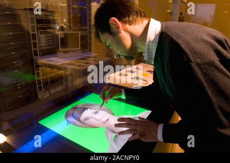 3D virtual avatar construction. Man using a computer program and touchscreen computer to create a 3D computer persona (avatar) in the likeness of a re Stock Photo
