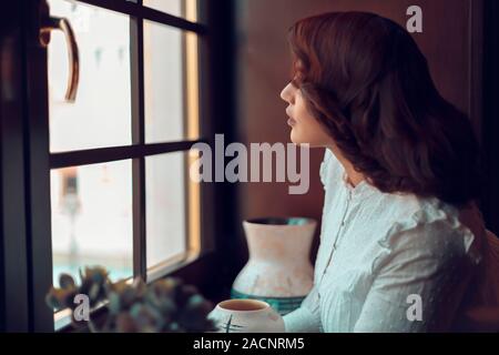 A Girl Looking Through Window Stock Photo