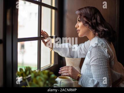 A Girl Looking Through Window Stock Photo