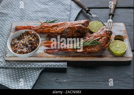 Close-up hot smoked fish on a wooden cutting board. Red sea bass fillet. Stock Photo
