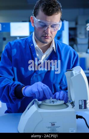 Scientist loading a sample into a centrifuge. Stock Photo