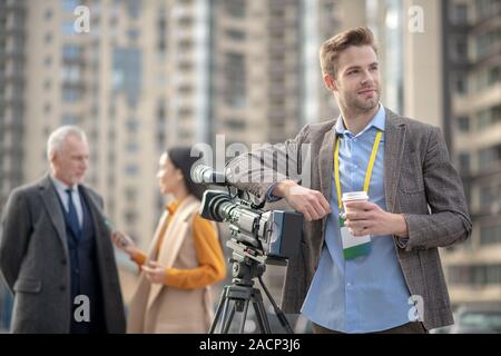 Young handsome reporter feeling good during break in work Stock Photo