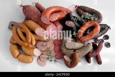 Charcuterie sausages. Assorted selection of cooked, cured and smoked sausages on a chopping board. Stock Photo