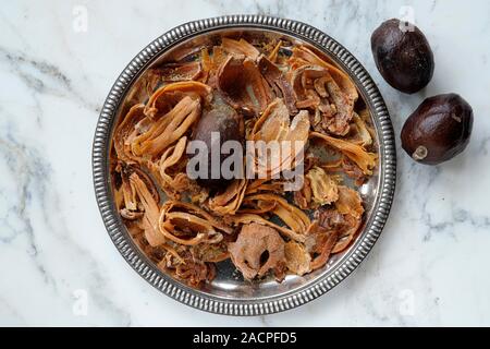 Nutmegs (Myristica fragrans) and mace, macis, in bowl, India Stock Photo