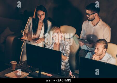Portrait of nice attractive smart clever skilled intellectual hardworking coworkers specialists developing new launch solving finance issue late at Stock Photo