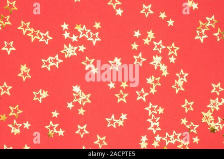 Golden stars Christmas background on bright red, flatlay, selective focus Stock Photo