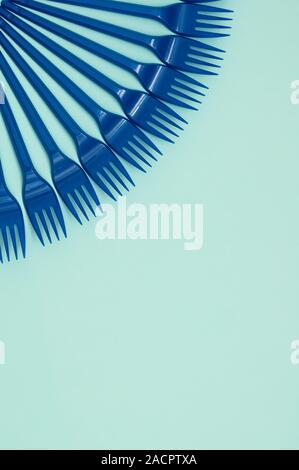 Blue plastic forks on a blue background, vertical orientation, copy space, place for text Stock Photo