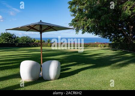 pair of chairs under a parasol looking out to sea on the Island of Maui, Hawaii, USA Stock Photo