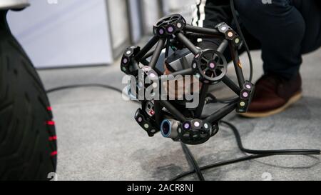 Taiwan-26 April, 2019: Man hand scanning a motorcycle using a measuring machine 3D scan high precision part for reverse engineering. Portable 3D scann Stock Photo