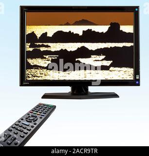 Digital television and remote control. Digital flat-screen television using HDMI (High-Definition Multimedia Interface), operated with an infrared rem Stock Photo