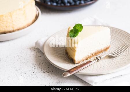 Slice Of Classical New York Cheesecake On White Plate. Closeup View. Home bakery concept/ Stock Photo