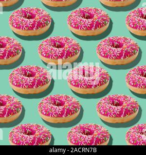 Bright food seamless isometric pattern with donuts.Pink glazed donuts with colorful sugar sprinkles on blue turquoise background Stock Photo