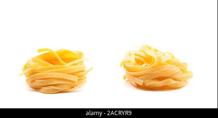 Two fettuccini pasta nests isolated on white. Stock Photo