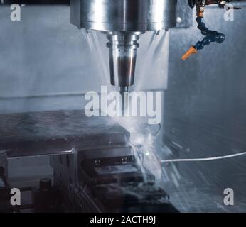 CNC milling machine cutting workpiece with coolant Stock Photo