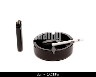Black ceramic ashtray with cigarette and lighter. Stock Photo