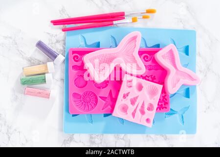 Flat lay. Ingredients to make chocolate mermaid molds from the chocolate chips. Stock Photo