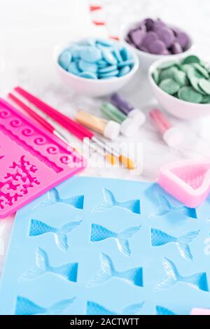 Flat lay. Ingredients to make chocolate mermaid molds from the chocolate chips. Stock Photo