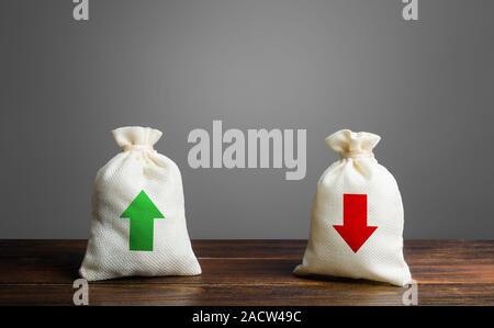 Two bags with red and green arrows. The concept of income and expenses. Trade balance and budgeting. Financial management, profit and loss. Business l Stock Photo
