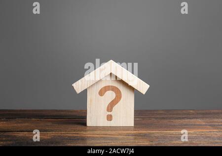 Question mark on a wooden house. Solving housing problems, deciding to buy or rent real estate. Search for options, the choice of accommodation betwee Stock Photo
