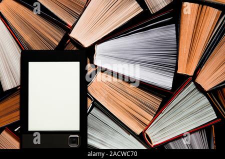 The e-book with a clean white screen rests on the open multi-colored books. ready to read Stock Photo
