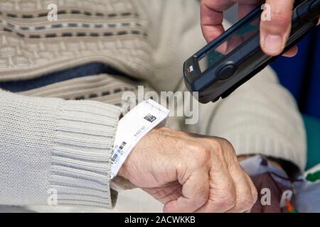 This is a real situation. Image not to be used in a defamatory context. Scanning patient details. Nurse using a device to scan a patient's details fro Stock Photo