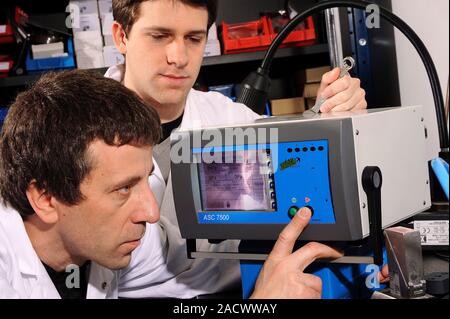Solenoid valve testing. Engineers operating an 8-channel solenoid valve. They work for French company ASC Instrument, which specialises in industrial Stock Photo