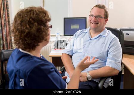 General practitioner (GP) and practice nurse having a meeting. Stock Photo
