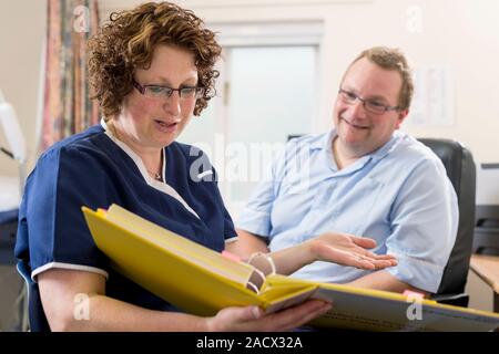 Doctor having a discussion with a practice nurse and going over some documents. Stock Photo