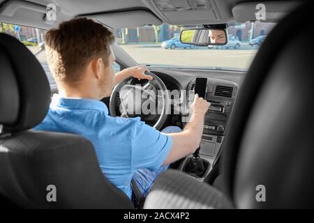 transport, vehicle and people concept - man or driver driving car and using gps navigator on smartphone Stock Photo
