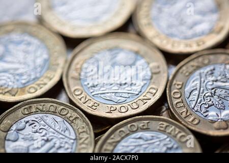 Close up of a pile of British Pound Coins with selective focus on the words 'One Pound' Stock Photo