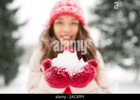 people, season and christmas concept - close up of happy smiling teenage girl or young woman with snow in winter Stock Photo