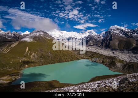 Panoramic aerial view over Gokyo Lake, the village, Gokyo Ri and Ngozumpa glacier from Gokyo Ri, Mt. Cho Oyu and Mt. Gyazung Kang in the distance Stock Photo