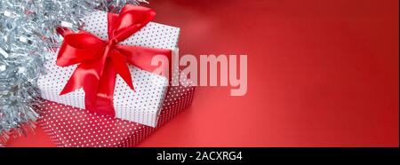 Christmas banner with gift box, tinsel. Gift concept for needlewoman on a red background Stock Photo