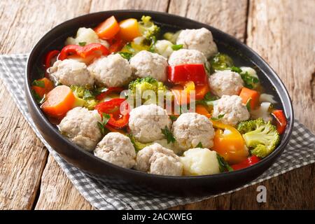 Serving soup with meatballs and vegetables close-up in a plate on the table. horizontal Stock Photo