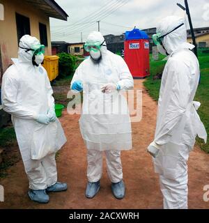 Doctors wearing personal protective equipment outside an ebola treatment unit in Nigeria, during the 2014 ebola virus disease (EVD) outbreak. EVD is a Stock Photo