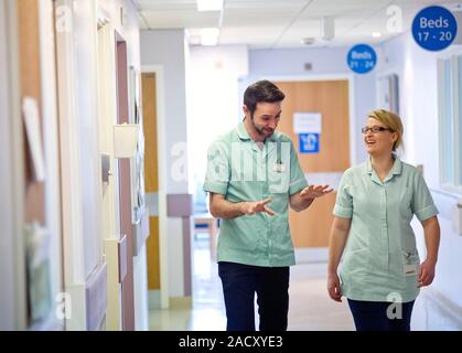 Apprentice clinical support workers walking along a hospital corridor. Stock Photo